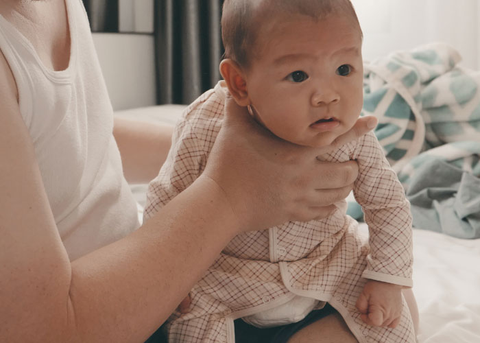 dad burping infant baby