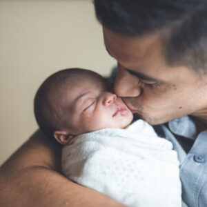 Dad holding and kissing baby