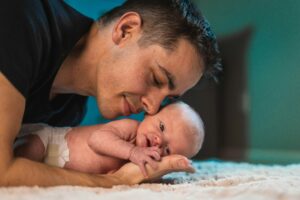 dad holding newborn cheek to cheek